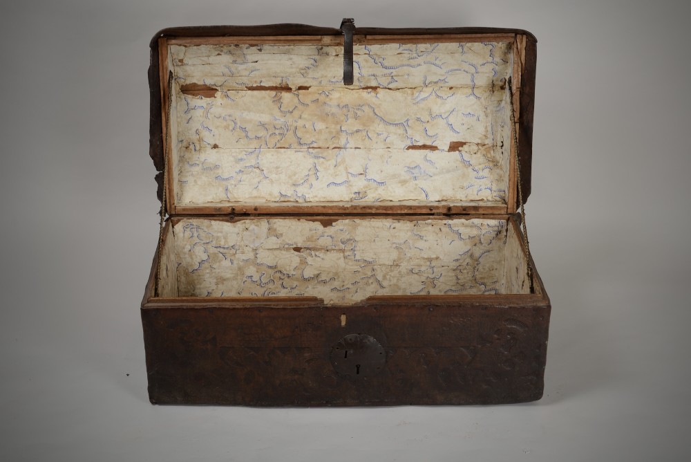 A 17th-century dark brown tooled leather coffer featuring a curved domed lid and central wrought iron lock plate. View III