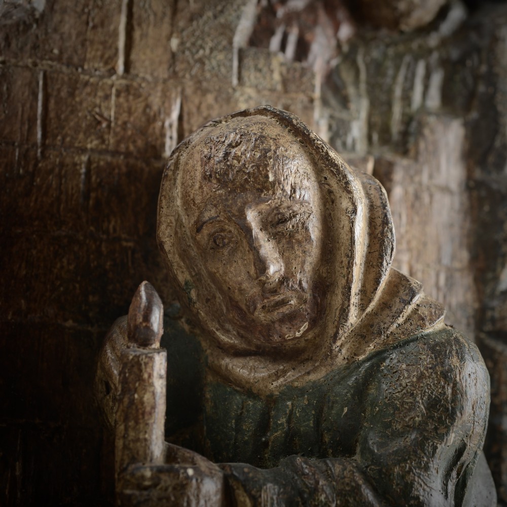 A late medieval carved wooden relief depicting the nativity with Mary, Joseph, and the Christ child under a thatched roof structure with traces of original polychrome paint. View IV