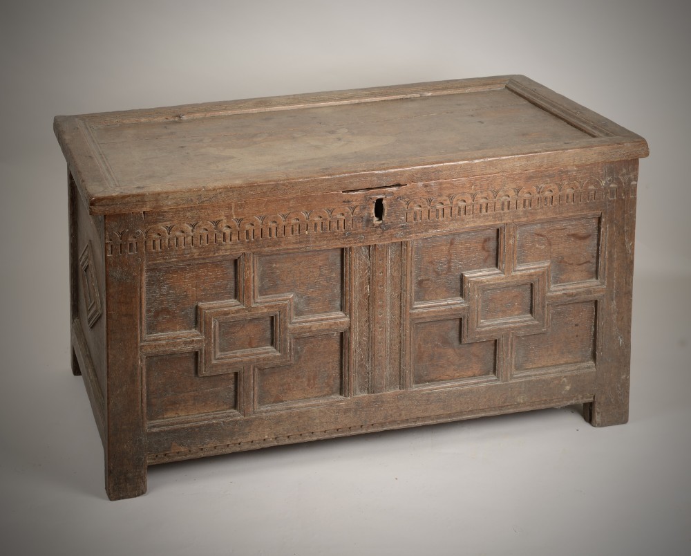A late Elizabethan dark oak coffer featuring geometric carved front panels, an arcaded frieze, and a central keyhole. View III