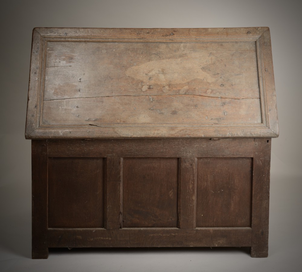 A late Elizabethan dark oak coffer featuring geometric carved front panels, an arcaded frieze, and a central keyhole. View IV