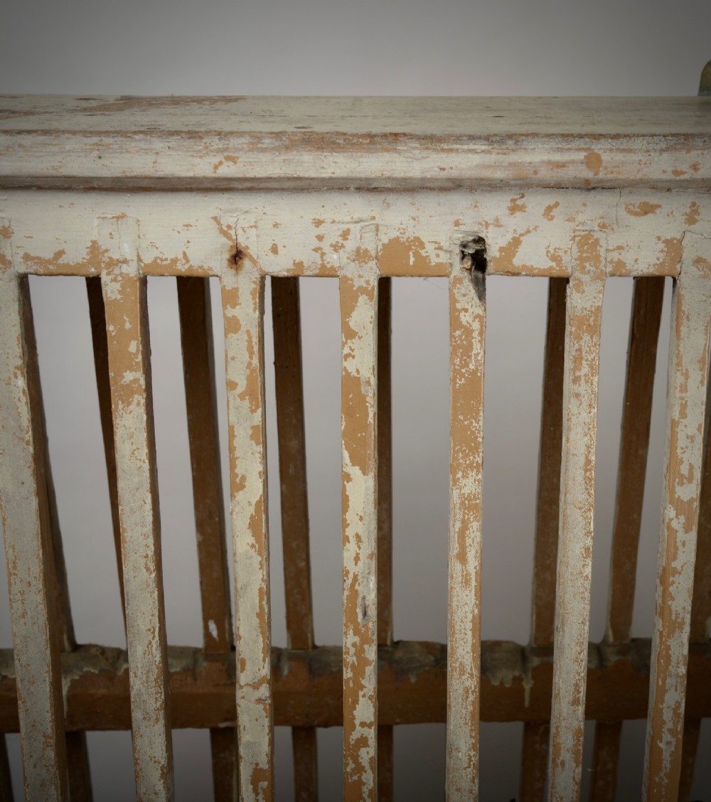 A two-tier painted wooden country house plate rack featuring a distressed off-white finish and vertical slotted spindles. View V