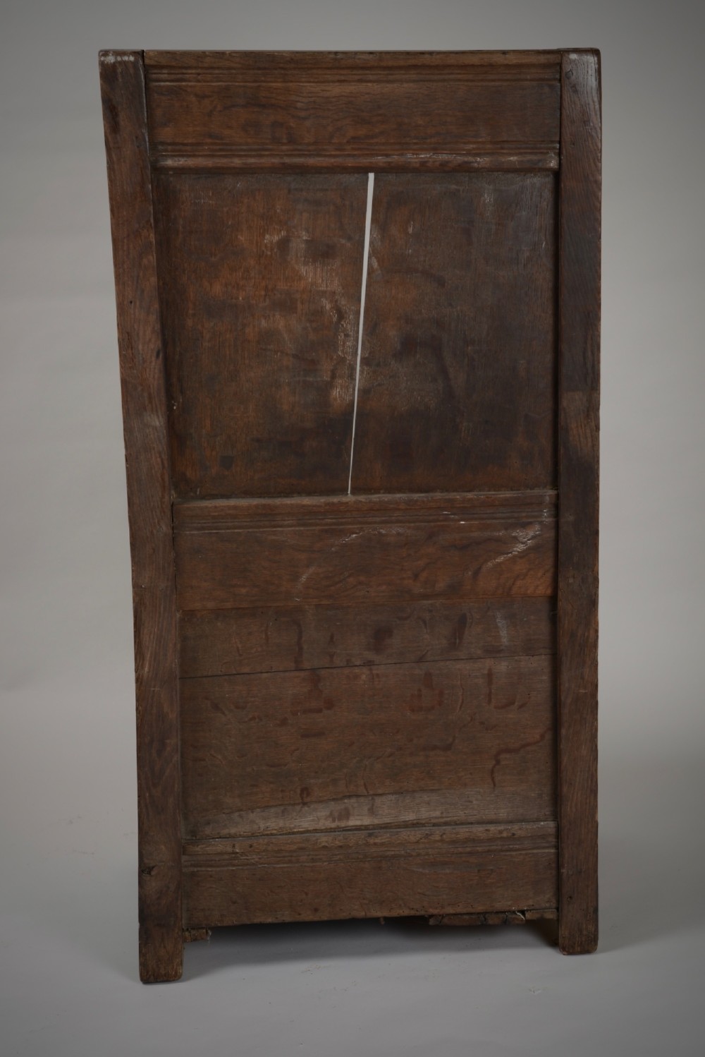 A dark oak late Elizabethan box chair featuring a high panelled back, curved armrests, and an enclosed wooden base. View VI