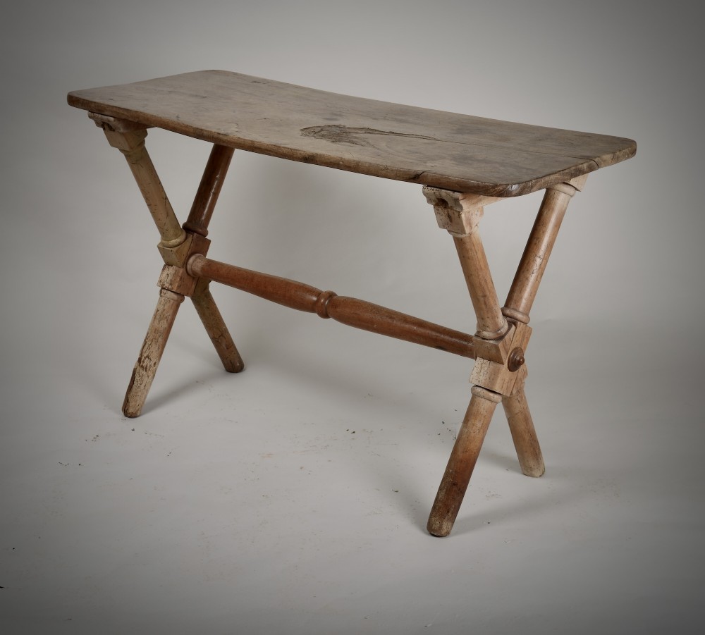 An antique rustic wooden tavern table featuring a rectangular plank top resting on an X-frame trestle base joined by a turned central stretcher.