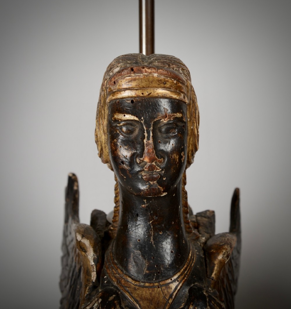 A pair of 18th-century ebonised and parcel-gilt carved wooden sphinx sculptures mounted on rectangular plinths and converted into table lamps with black shades. View VIII