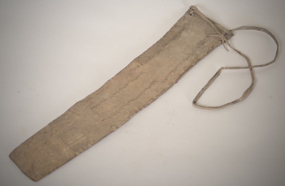 An antique Native American leather hide strip featuring geometric glass seed beadwork in white, red, blue, and green with hide ties attached. View V