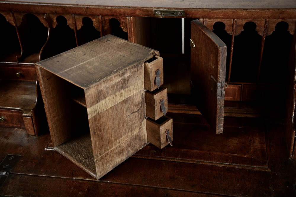 An 18th-century George II burr walnut bureau featuring a sloped fall-front flap above four graduated drawers with brass handles and bracket feet. View V