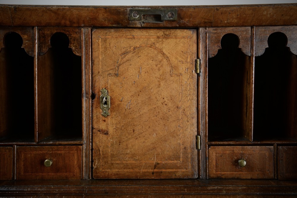 An 18th-century George II burr walnut bureau featuring a sloped fall-front flap above four graduated drawers with brass handles and bracket feet. View VI