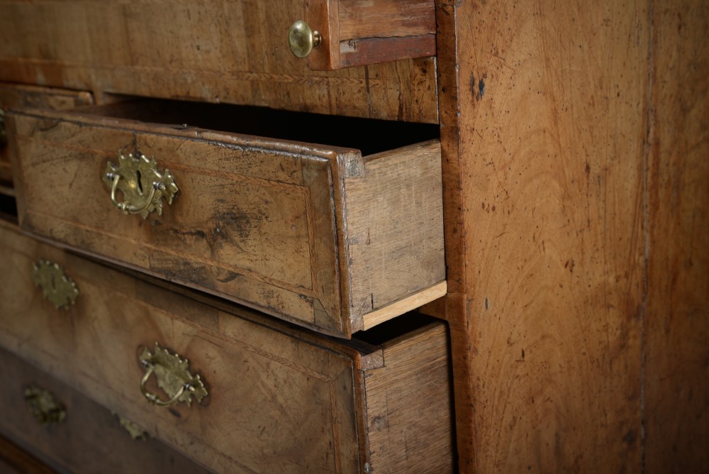 An 18th-century George II burr walnut bureau featuring a sloped fall-front flap above four graduated drawers with brass handles and bracket feet. View XI