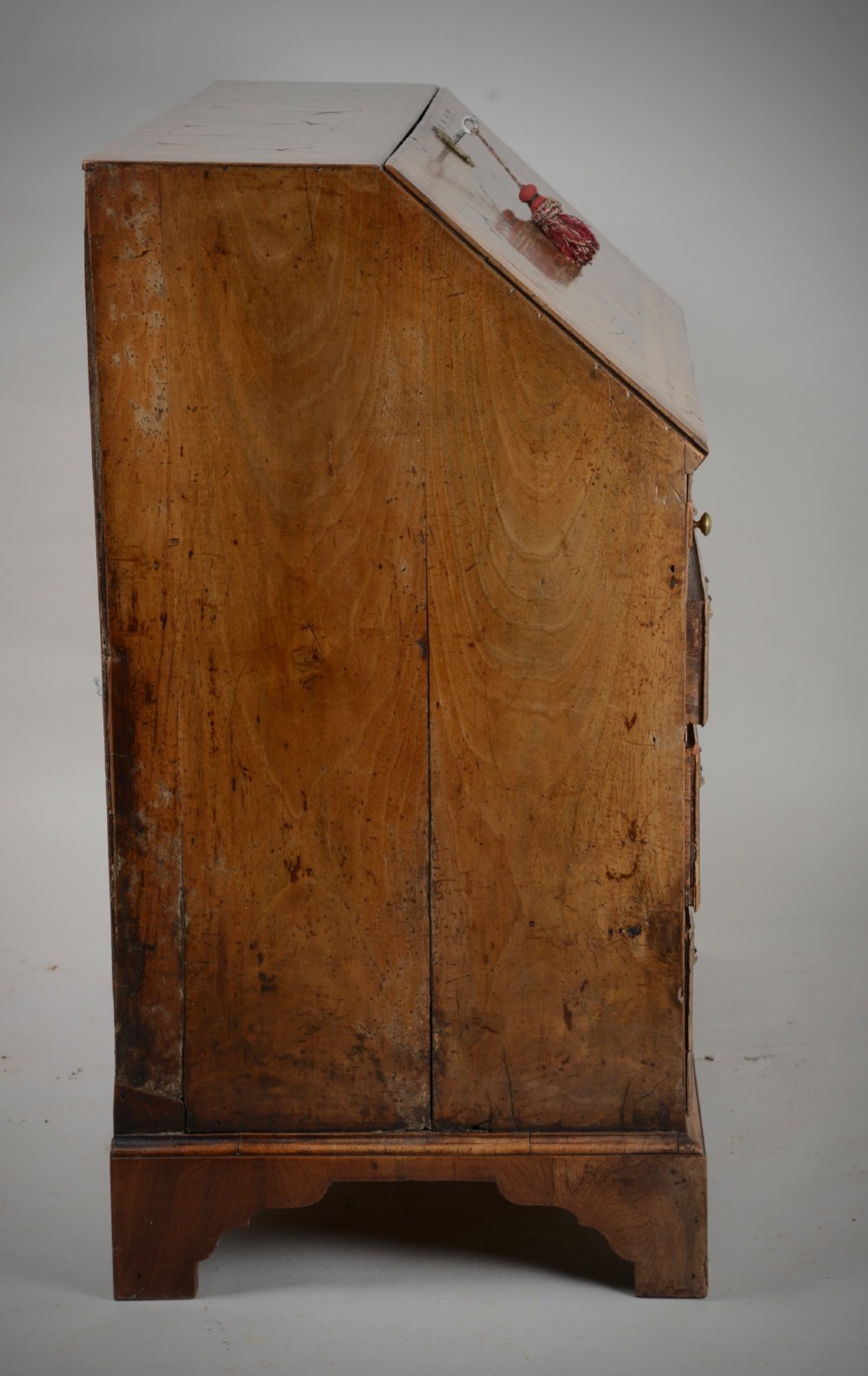 An 18th-century George II burr walnut bureau featuring a sloped fall-front flap above four graduated drawers with brass handles and bracket feet. View XIV