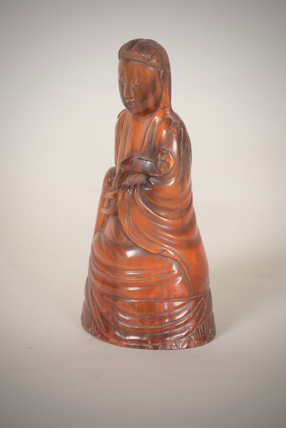 A hand-carved honey-brown horn figure depicting the Chinese deity Guanyin in flowing draped robes. View II