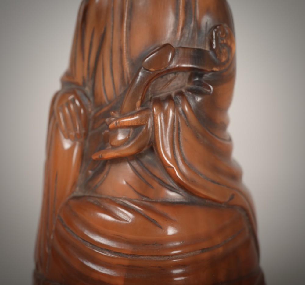 A hand-carved honey-brown horn figure depicting the Chinese deity Guanyin in flowing draped robes. View VI