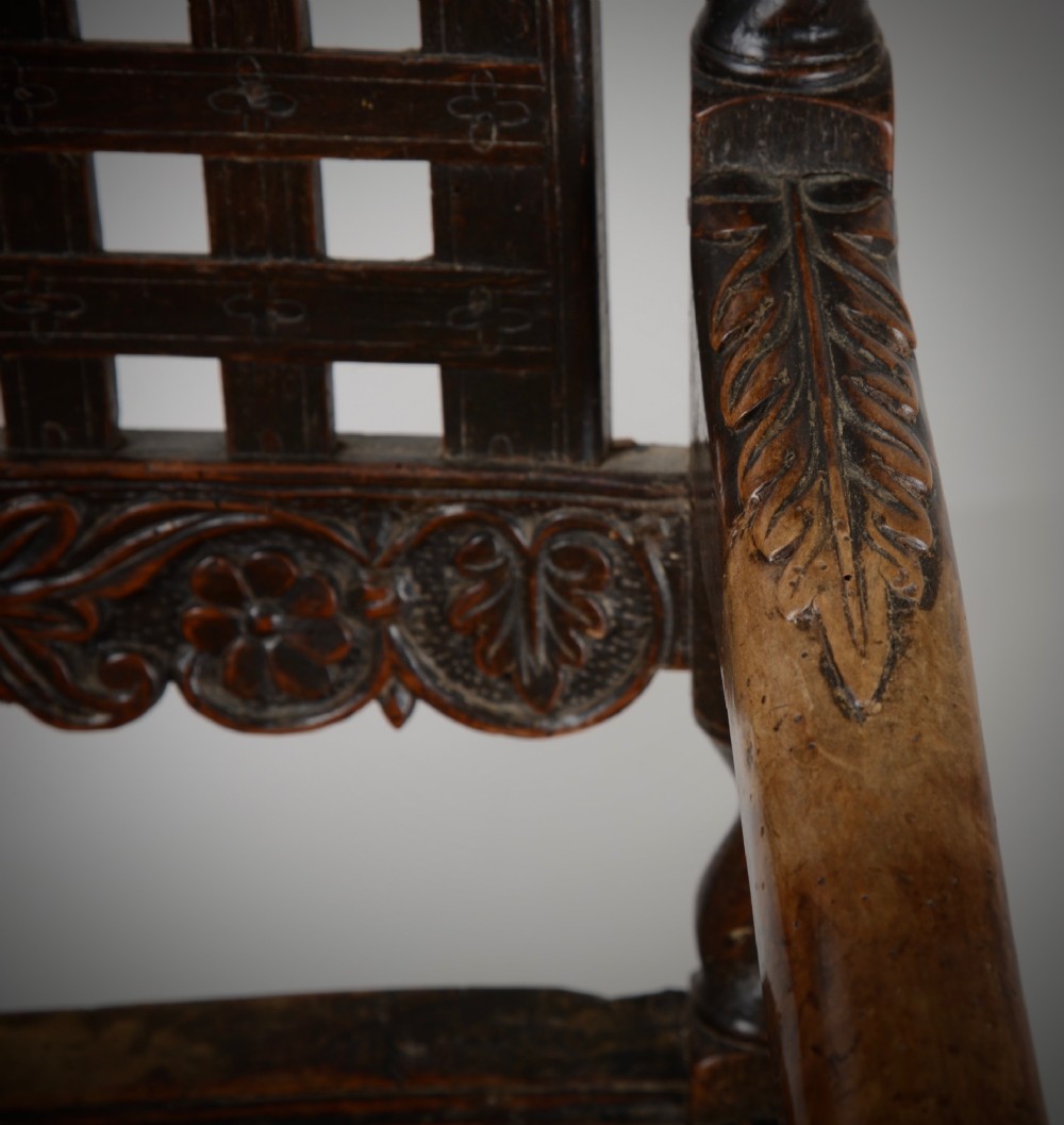 A dark walnut Charles II style open armchair featuring intricate barley twist uprights, a carved floral cresting rail, a slatted timber lattice back, and turned stretchers. View X