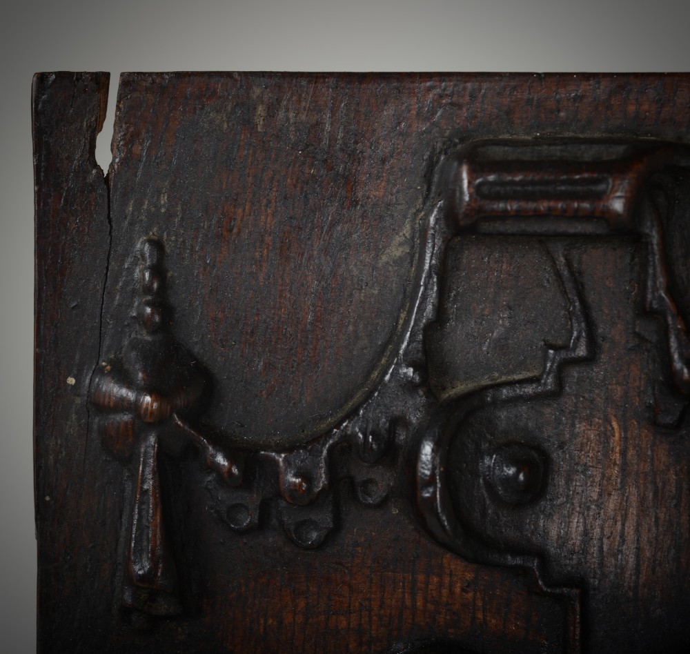 A dark brown rectangular carved oak panel depicting a central relief figure in armour framed by intricate strapwork and decorative scrollwork. View III