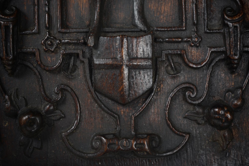 A dark brown rectangular carved oak panel depicting a central relief figure in armour framed by intricate strapwork and decorative scrollwork. View IV