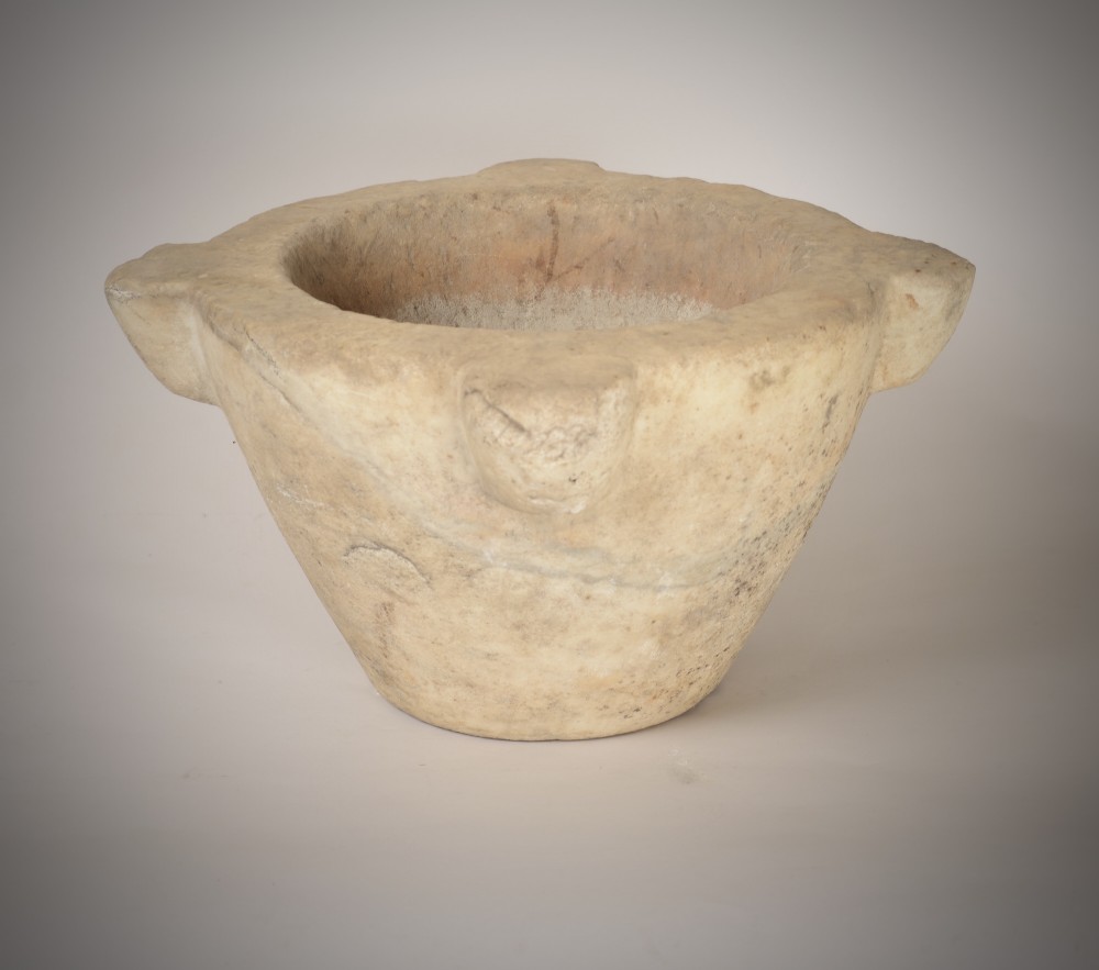 A large, hand-carved off-white marble mortar featuring tapered sides and prominent carved side lugs. View II