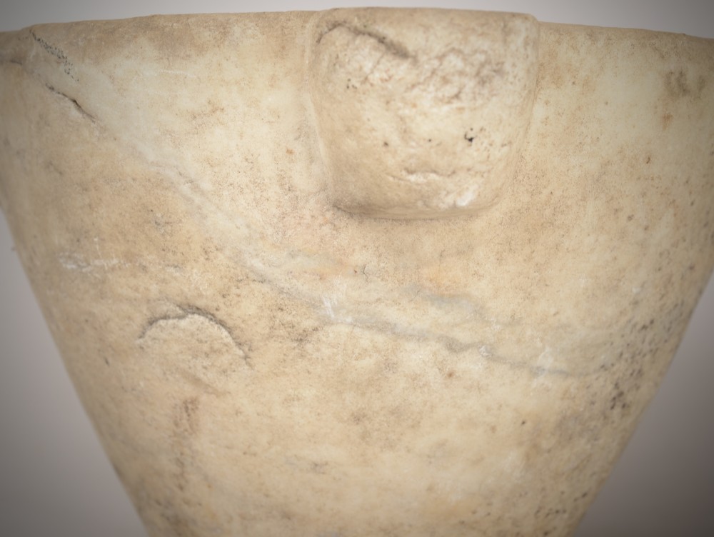 A large, hand-carved off-white marble mortar featuring tapered sides and prominent carved side lugs. View III
