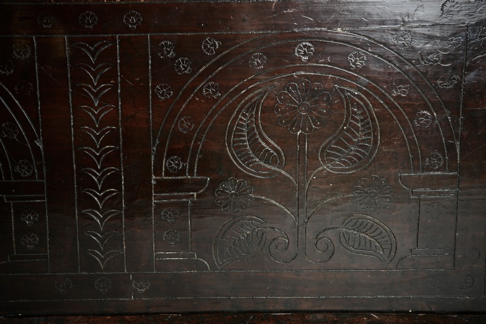 A dark brown 17th-century carved oak coffer featuring three carved arch panels, a central shield panel inscribed with the date 1644, and a shaped lower apron. View II