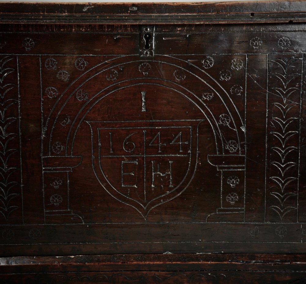 A dark brown 17th-century carved oak coffer featuring three carved arch panels, a central shield panel inscribed with the date 1644, and a shaped lower apron. View III