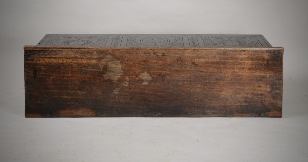 A dark brown 17th-century carved oak coffer featuring three carved arch panels, a central shield panel inscribed with the date 1644, and a shaped lower apron. View VII