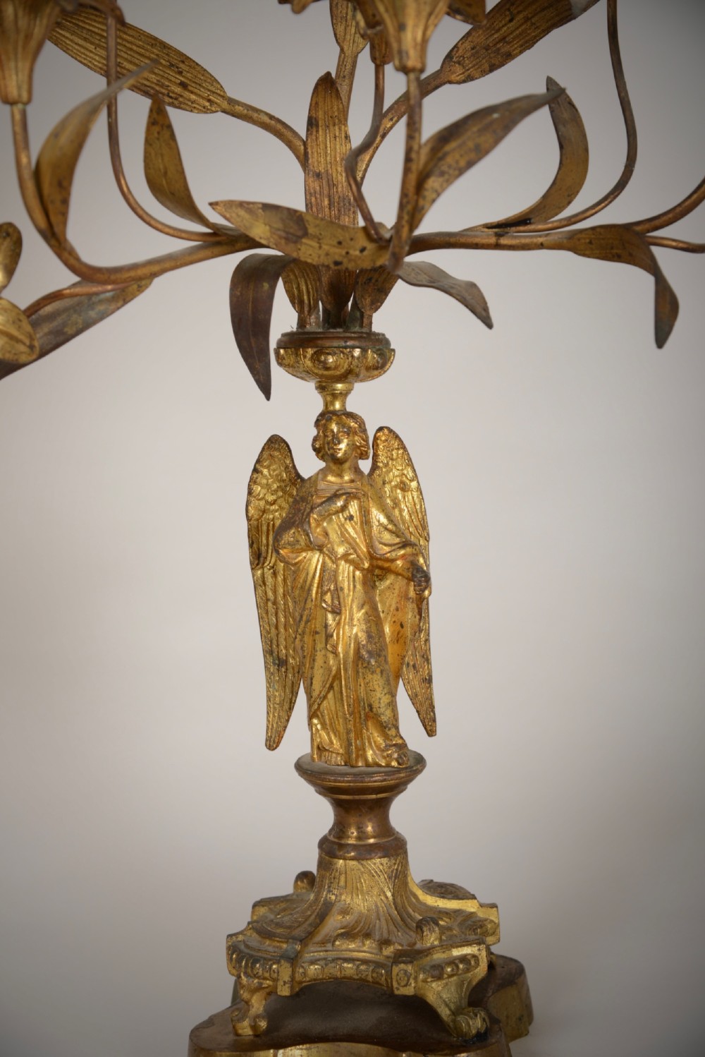 A pair of gilt brass Gothic Revival candelabra featuring sculpted angel pedestal bases and branching lily arms holding candles. View IV