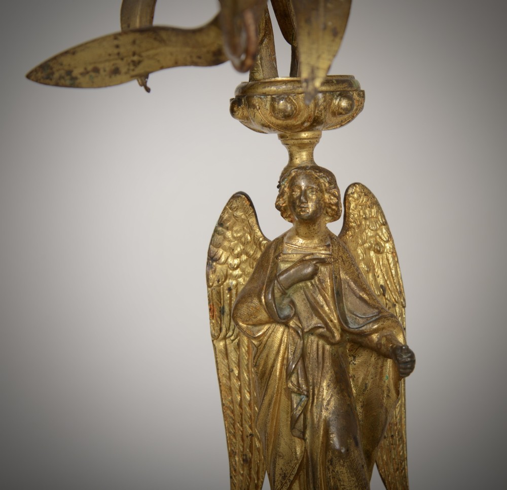 A pair of gilt brass Gothic Revival candelabra featuring sculpted angel pedestal bases and branching lily arms holding candles. View VI