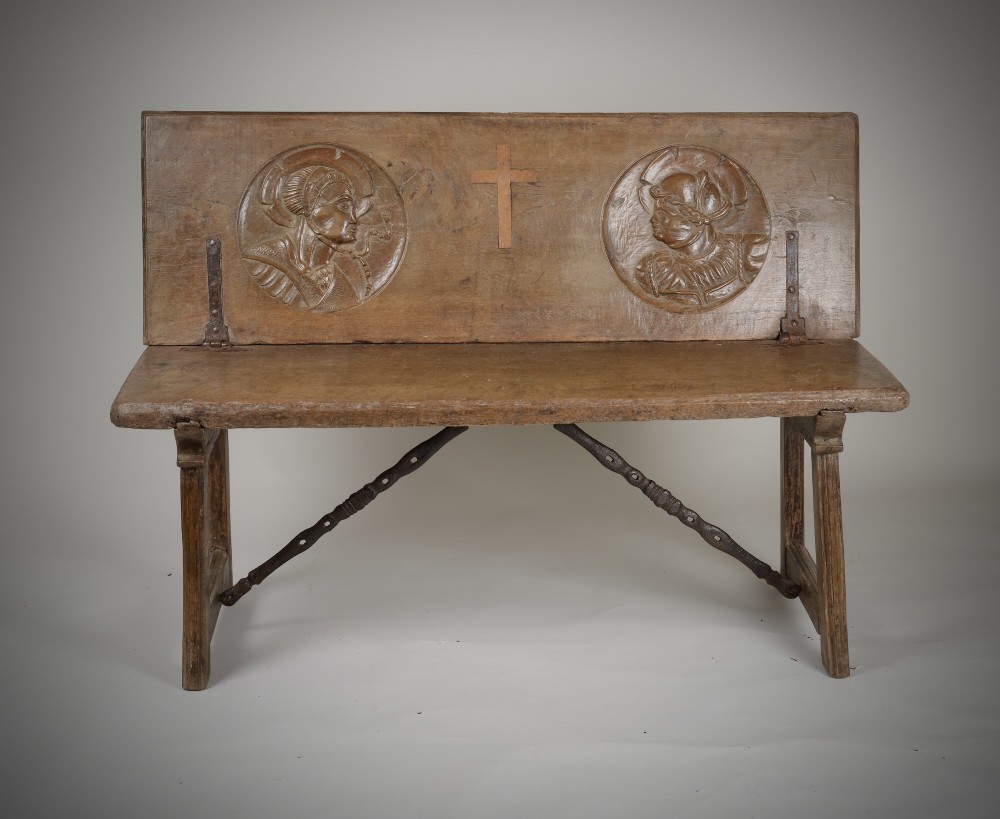 A Renaissance style carved wooden bench featuring two profile portrait roundels flanking a central cross on the backrest and wrought iron support stretchers beneath. View II