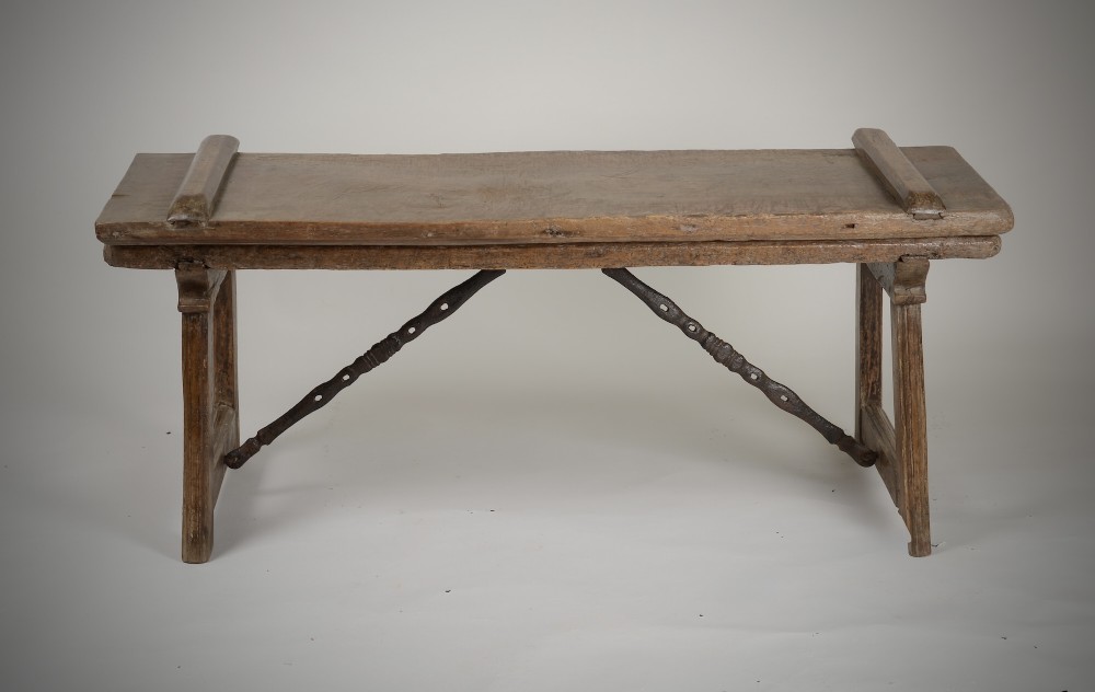 A Renaissance style carved wooden bench featuring two profile portrait roundels flanking a central cross on the backrest and wrought iron support stretchers beneath. View III