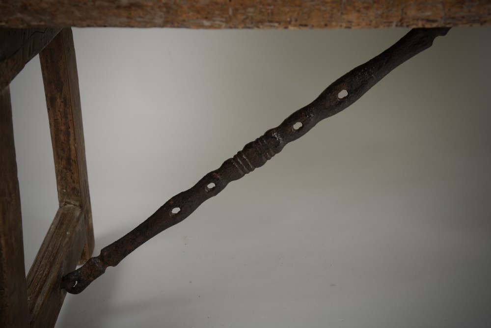 A Renaissance style carved wooden bench featuring two profile portrait roundels flanking a central cross on the backrest and wrought iron support stretchers beneath. View VII