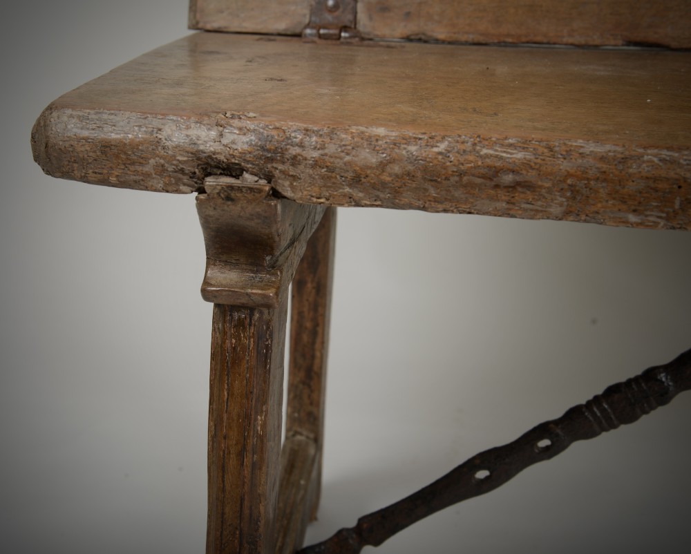A Renaissance style carved wooden bench featuring two profile portrait roundels flanking a central cross on the backrest and wrought iron support stretchers beneath. View VIII