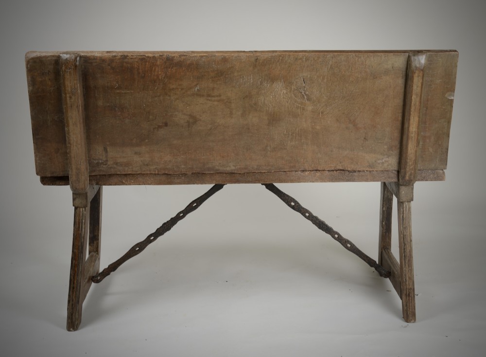 A Renaissance style carved wooden bench featuring two profile portrait roundels flanking a central cross on the backrest and wrought iron support stretchers beneath. View IX