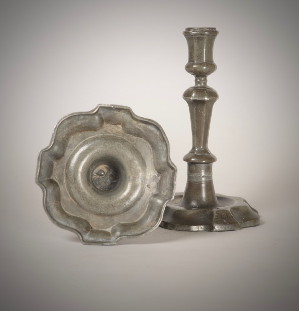 A pair of 18th-century pewter candlesticks featuring baluster stems and shaped scalloped bases. View III