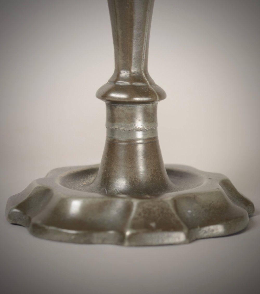 A pair of 18th-century pewter candlesticks featuring baluster stems and shaped scalloped bases. View IV