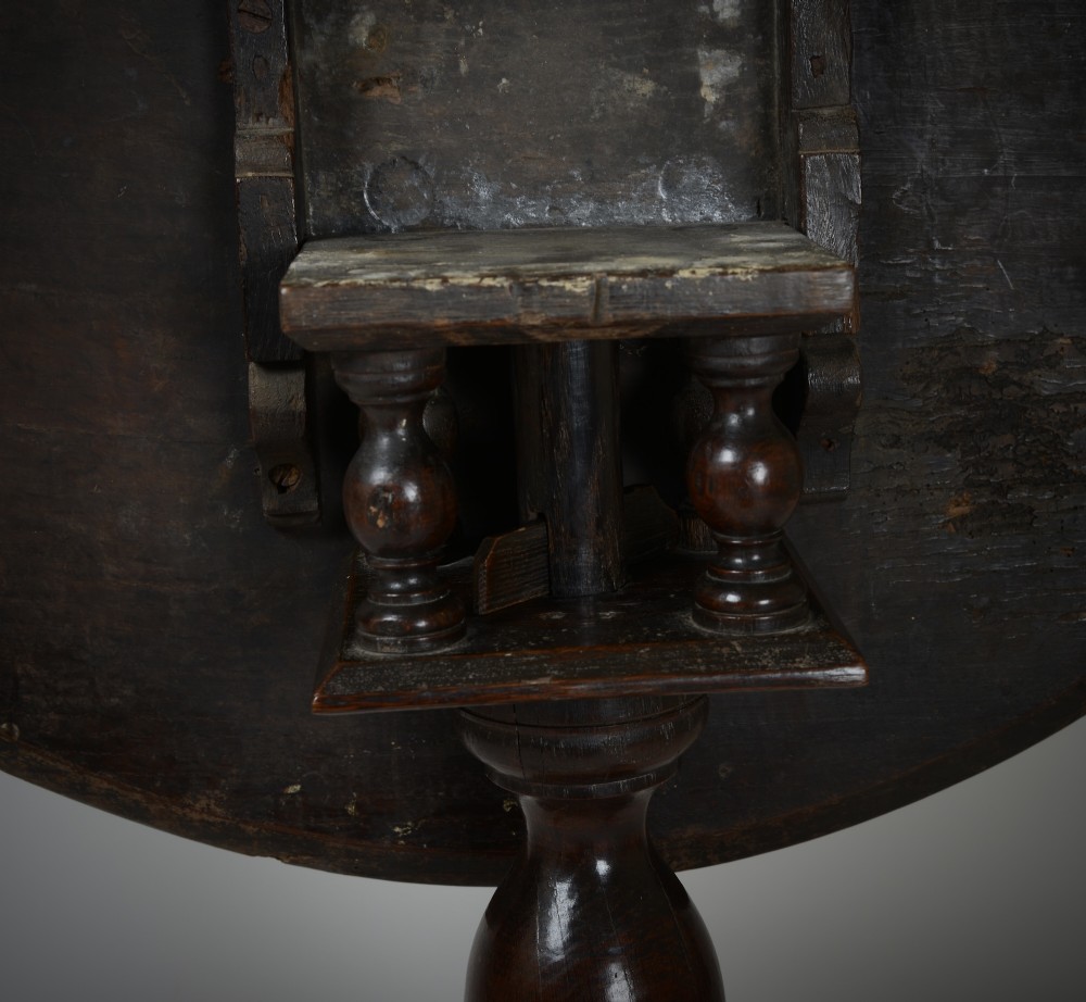 An antique dark brown oak tripod table featuring a circular top, a birdcage support mechanism, a turned central column, and three splayed feet. View V