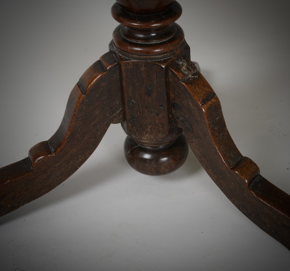 An antique dark brown oak tripod table featuring a circular top, a birdcage support mechanism, a turned central column, and three splayed feet. View VI
