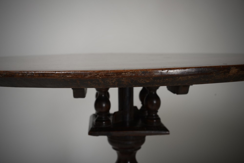 An antique dark brown oak tripod table featuring a circular top, a birdcage support mechanism, a turned central column, and three splayed feet. View IX