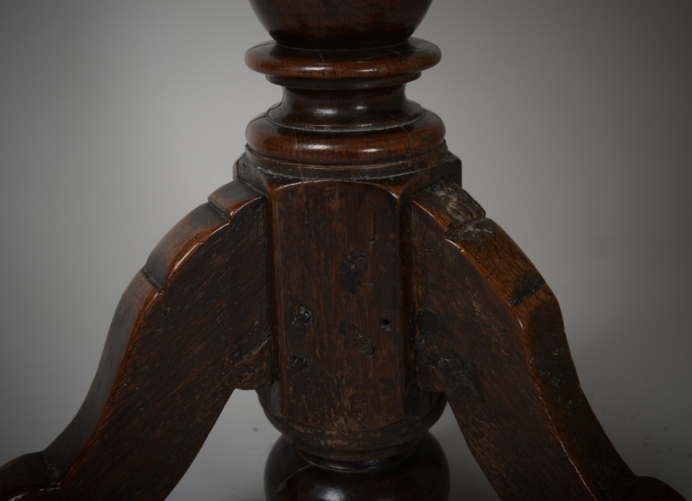 An antique dark brown oak tripod table featuring a circular top, a birdcage support mechanism, a turned central column, and three splayed feet. View X