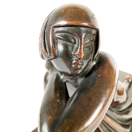 An Art Deco dark patinated bronze sculpture depicting a stylised female figure resting on an integrated rectangular bronze base. View II