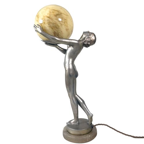 An Art Deco spelter table lamp featuring a silvered female figure holding up an amber glass globe shade on a circular onyx base. View III