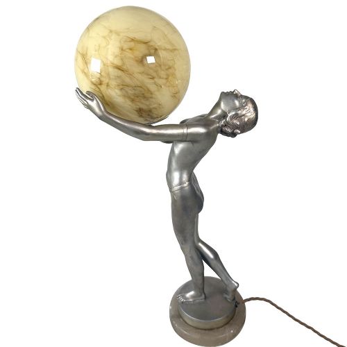 An Art Deco spelter table lamp featuring a silvered female figure holding up an amber glass globe shade on a circular onyx base. View IV