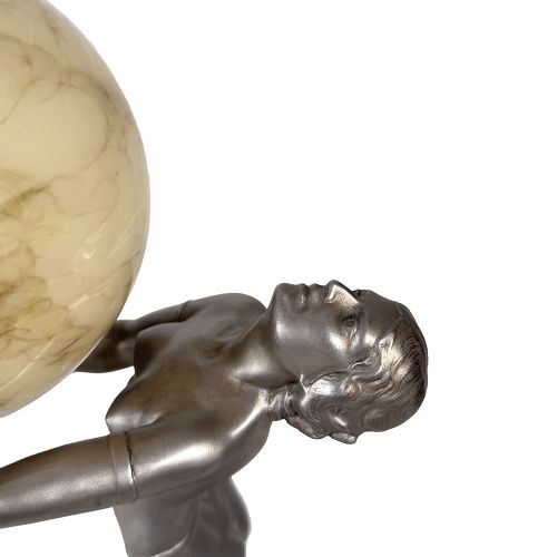 An Art Deco spelter table lamp featuring a silvered female figure holding up an amber glass globe shade on a circular onyx base. View V