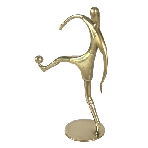A stylised brass statuette depicting a footballer balancing a football on his foot set upon a circular base. View IV