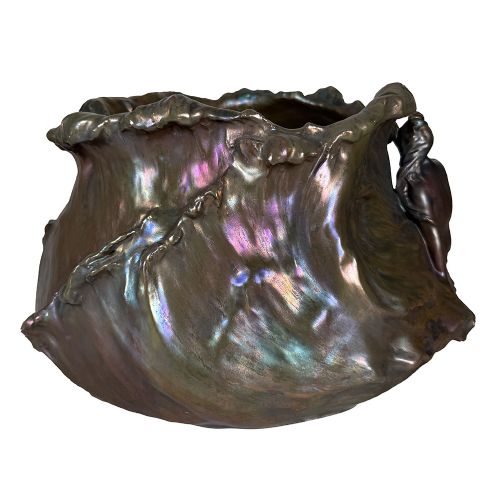 An Art Nouveau ceramic planter featuring an iridescent bronze and purple lustre glaze with a sculpted reclining female figure along undulating wave forms. View V