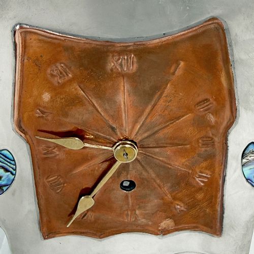 An Arts and Crafts pewter mantel clock featuring a square copper dial with Roman numerals and three iridescent abalone shell cabochon inlays. View V