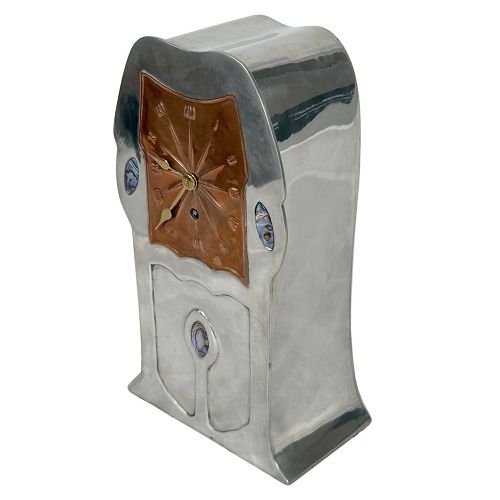 An Arts and Crafts pewter mantel clock featuring a square copper dial with Roman numerals and three iridescent abalone shell cabochon inlays. View VI