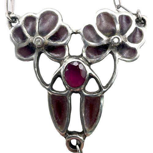 An Art Nouveau silver chain necklace featuring a stylized floral pendant inlaid with dark red enamel, a central ruby, and a pearl drop. View IV