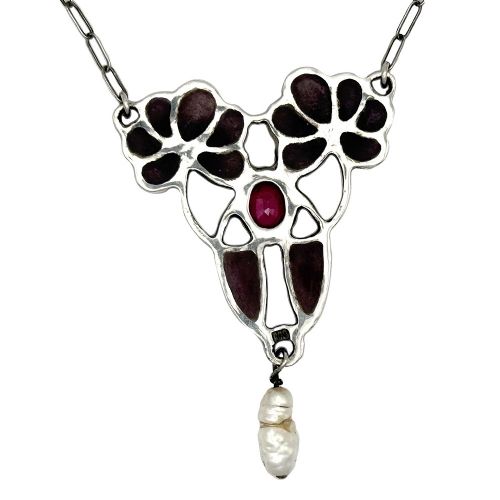 An Art Nouveau silver chain necklace featuring a stylized floral pendant inlaid with dark red enamel, a central ruby, and a pearl drop. View V