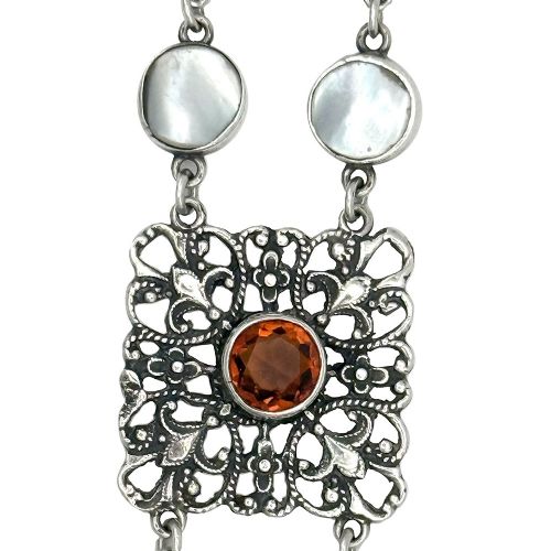 An Arts and Crafts period silver link bracelet featuring intricate openwork square panels set with central round orange citrines, connected by paired circular blister pearls. View II