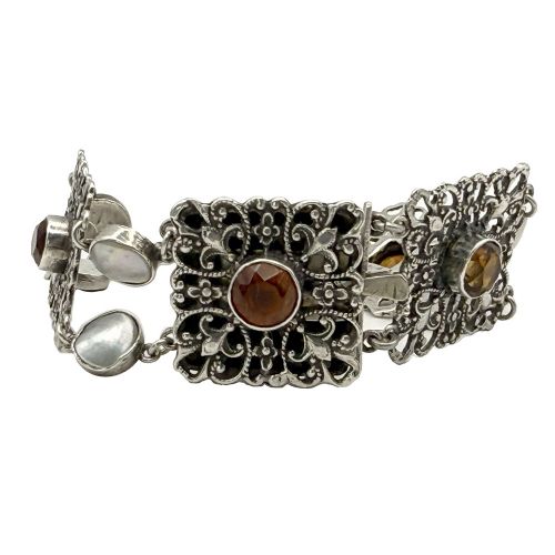 An Arts and Crafts period silver link bracelet featuring intricate openwork square panels set with central round orange citrines, connected by paired circular blister pearls. View III