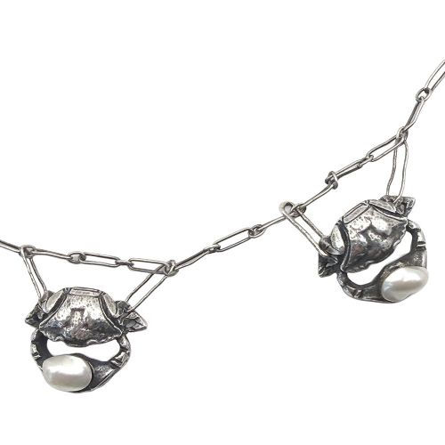 An Art Nouveau silver chain necklace featuring three crab motif drops, each holding an iridescent river pearl. View III
