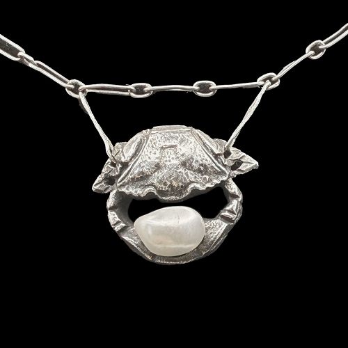 An Art Nouveau silver chain necklace featuring three crab motif drops, each holding an iridescent river pearl. View V